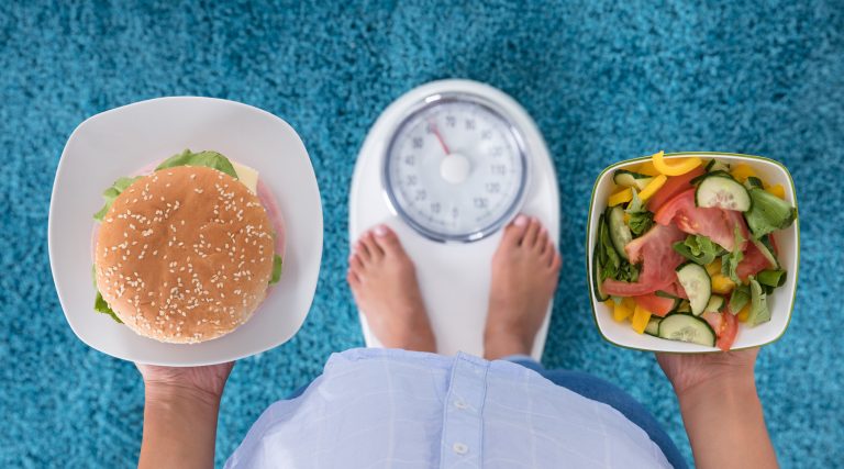 Person Holding Plates Of Burger And Salad